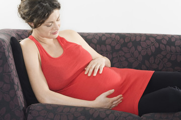 Portrait of a pregnant young woman relaxing on sofa