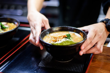 Cook geeting ready the Ramen for serving