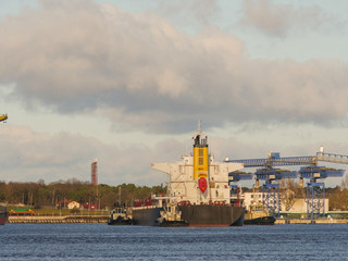 Tug vessels assisting bulk cargo ship to leave port