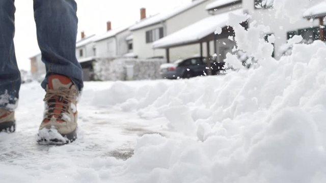 CLOSE UP: Man cleaning fresh snow in front of the house in idyllic suburban town