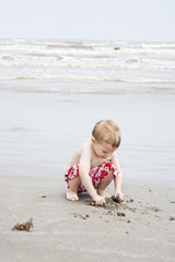 Full length of a little boy playing with sand on beach