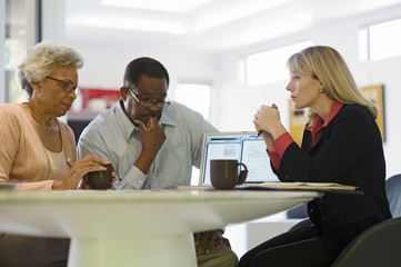 Serious African American couple in a meeting with female financial advisor at home