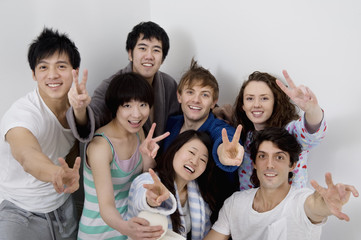 Group portrait of young friends showing peace sign