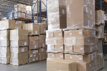 Cardboard boxes stacked in distribution warehouse