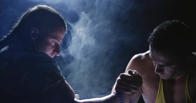 Two strong mans armwrestling in atheletic common-room