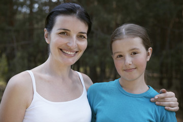 Closeup portrait of a mother and daughter against blurred plants
