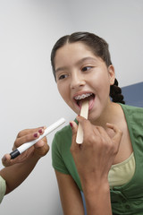 Closeup of a young girl having her throat examined