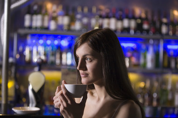 Closeup of a thoughtful young woman drinking tea at a recreational bar