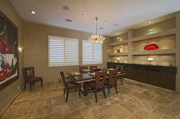 Lit of chandelier hanging over dining table in spacious room