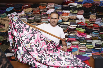 Portrait of confident fabric store owner working at counter