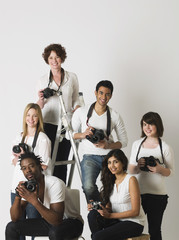 Fototapeta na wymiar Group portrait of multiethnic young people holding cameras in studio