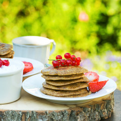 Breakfast in the garden: paleo style grain free banana almond pancakes,  selective focus, square