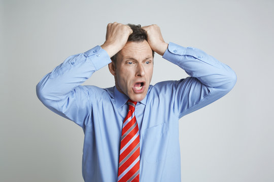 Frustrated Businessman Pulling His Hair Isolated Over Grey Background