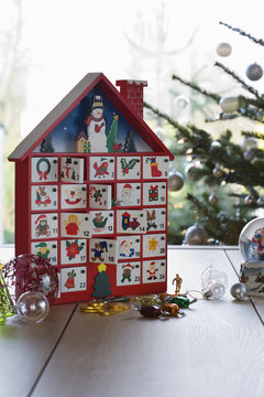 Kid's Christmas calendar and ornaments on table