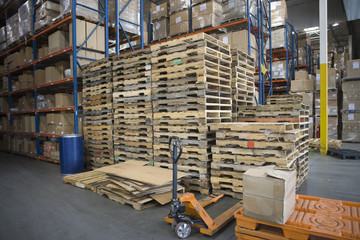 Wooden pallets stacked in distribution warehouse