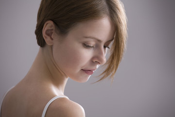 Closeup of a pensive young woman against colored background