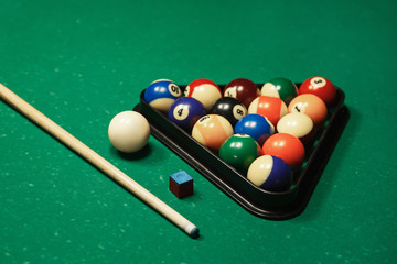 Billiard balls near by cue and chalk.