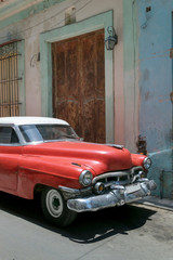 Red american car parked in the streets of Old Havana, Cuba