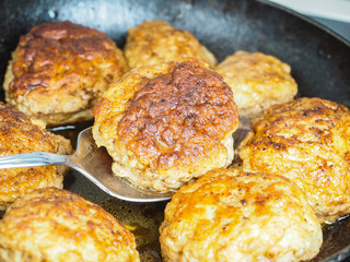 Frying homemade meatballs in black iron pan, in fine broth