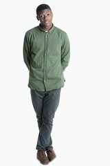Fototapeta premium Portrait of a young African American man standing with legs crossed over gray background