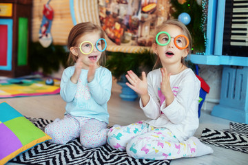 children with glasses in the room sing. Two sisters. 