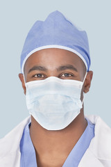 Fototapeta na wymiar Close-up of a male surgeon wearing mask over light blue background