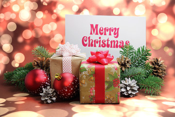Christmas card with pinecones and gift on brown background