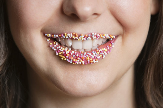 Cropped portrait of Middle Eastern woman with sprinkle candy lips