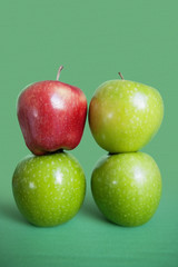 Stack of red and green apples over colored background