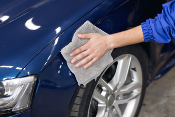 man polishing cleaning car with microfiber cloth,  detailing or valeting concept