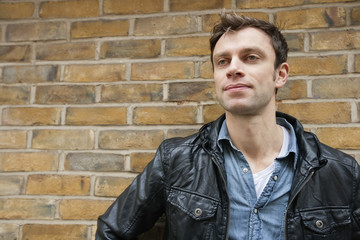 Mid-adult man in a leather jacket looking away
