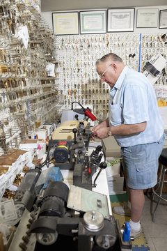 Side View Of Senior Locksmith Working In Store