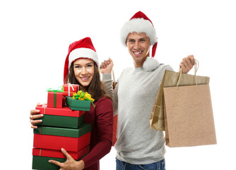 Young couple with Christmas purchases on white background