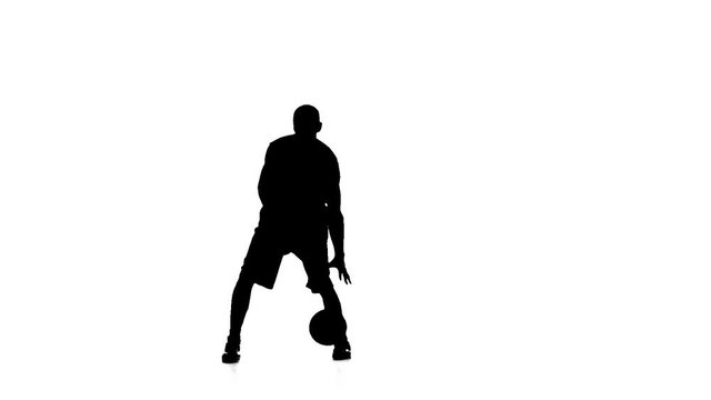 Basketball feint passes the ball. Silhouette. Slow motion. White background.