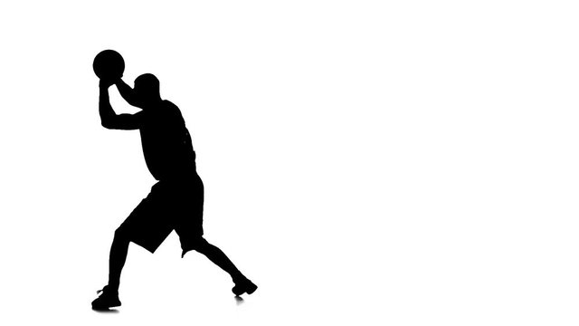 Basketball player holding the ball and makes a feint. Silhouette