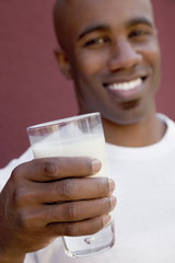 Close-up of young man holding milk glass