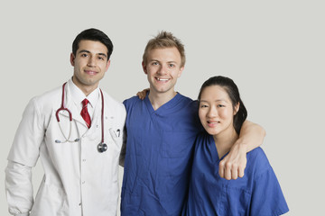 Portrait of friendly medical team standing over gray background