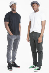 Portrait of two young African American men in casuals over gray background