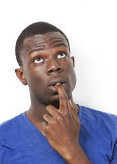 Fototapeta na wymiar Pensive young African American man with finger in mouth against white background