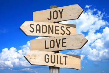 Wooden signpost with four arrows - joy, sadness, love, guilt - great for topics like feelings etc. - obrazy, fototapety, plakaty