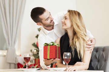 Man gives a woman a gift on Christmas Eve