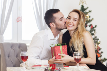 Man gives a woman a gift on Christmas Eve