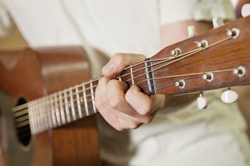 Close-up view of man's hand playing guitar