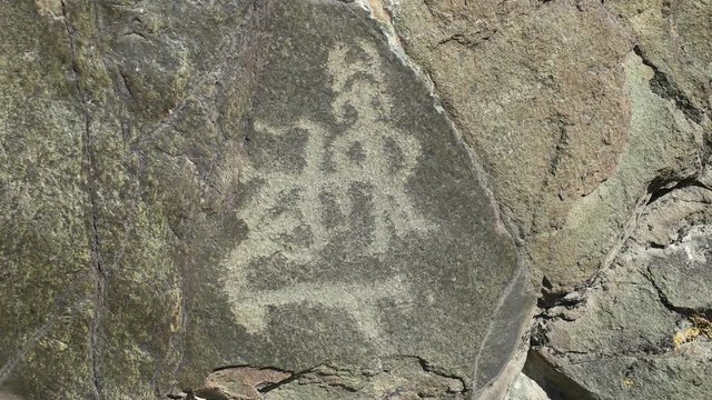 Ancient petroglyph of hunter and victim on the rock. Altay, Russia.