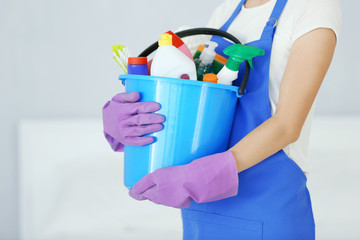 Close up view of woman with cleaning supplies at home