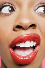 Cropped image of shocked young woman with red lips looking to her side