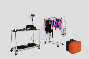 Clothes rack and reflector umbrella with suitcase in studio