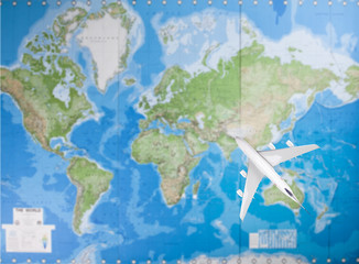 Fototapeta na wymiar Model airplane flying over world map