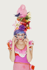 Portrait of beautiful young woman in Brazilian outfit over gray background