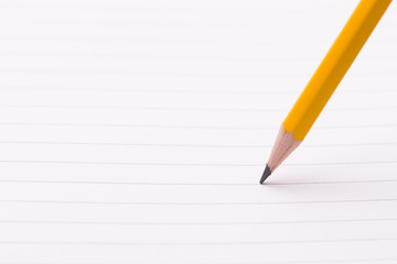 Closeup of a sharp pencil tip on white paper